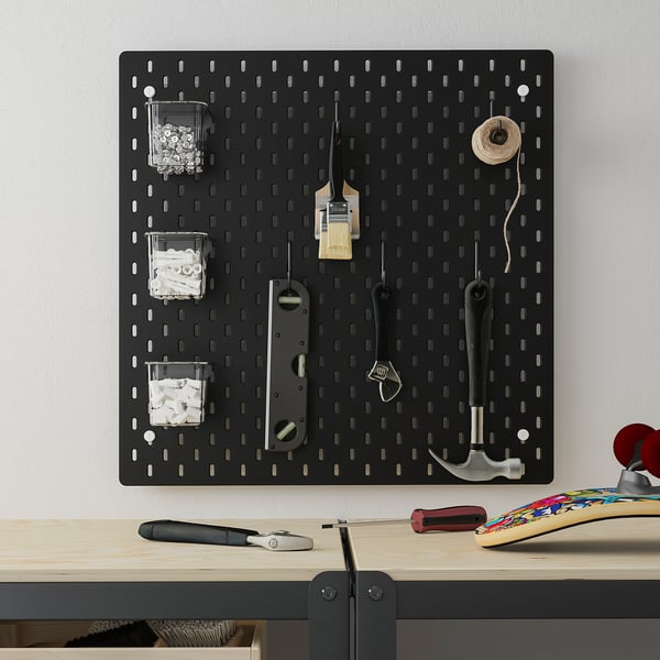 SKÅDIS pegboard organises tools on wall over desk with containers and items.
