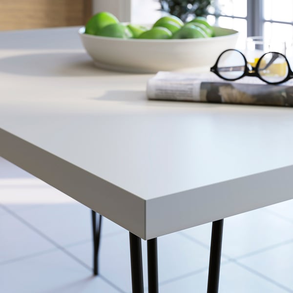Grey modern table with apples, glasses, and magazines.