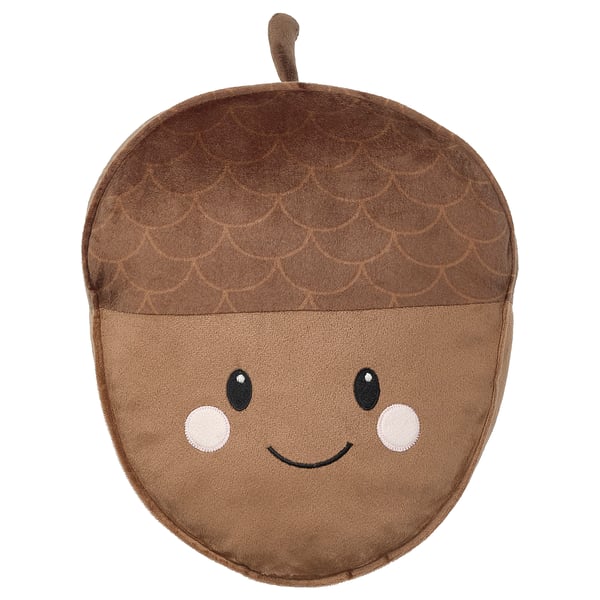 An acorn-shaped pillow named SKOGSDUVA with a brown shell design, a smiling face, and a secret pocket.