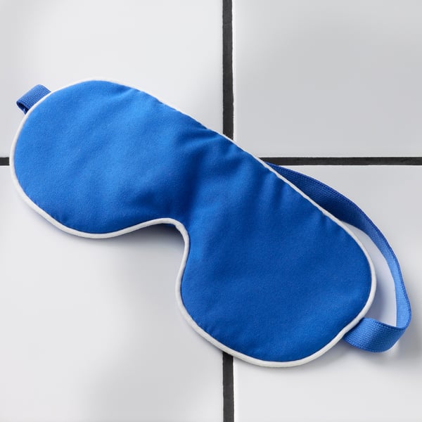Soft blue eye mask on white grid background. Adjustable strap, quality recycled fabric, blocks light.
