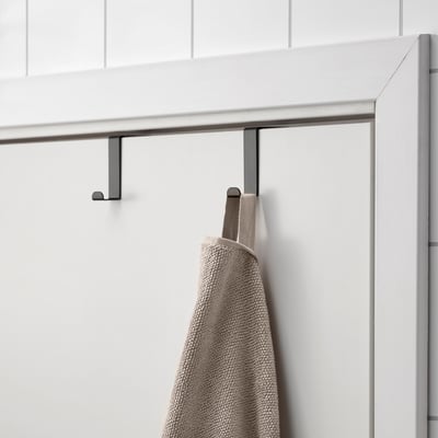 Black over-door towel hook with grey towel hanging, saving space efficiently.