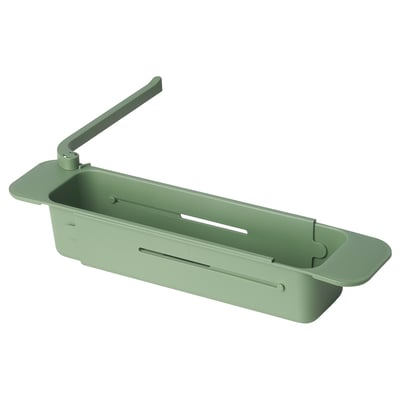 Depicts a green SKOLÄST kitchen sink organiser, featuring slots for brushes and a dishcloth holder.