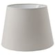 A grey SKOTTORP lampshade, cylindrical in shape, made of eco-friendly fabric and plastic frame.