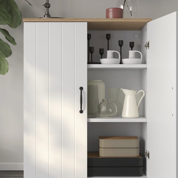 White SKRUVBY cabinet with shelves: candlesticks, vases, boxes.