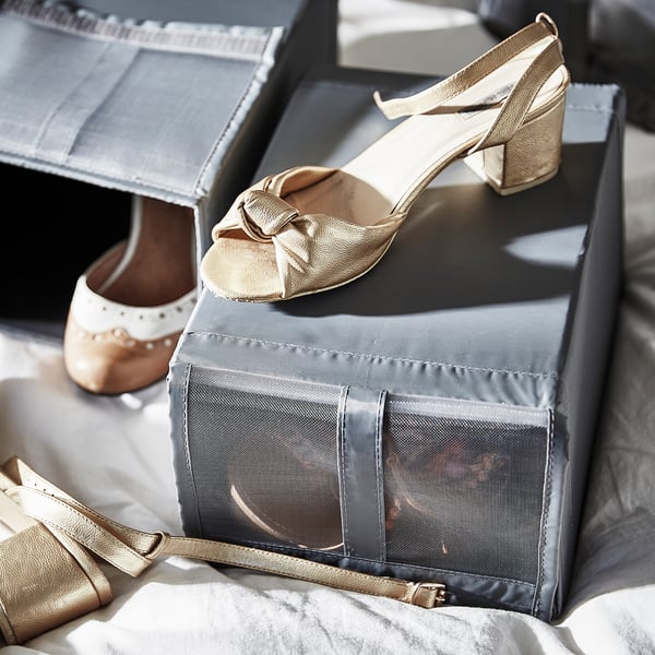 Gold heels with bow, on grey mesh box with hook and loop fastener.