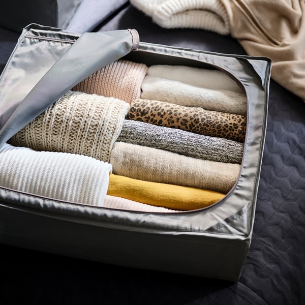 Clothes folded in storage case with handle for easy access.