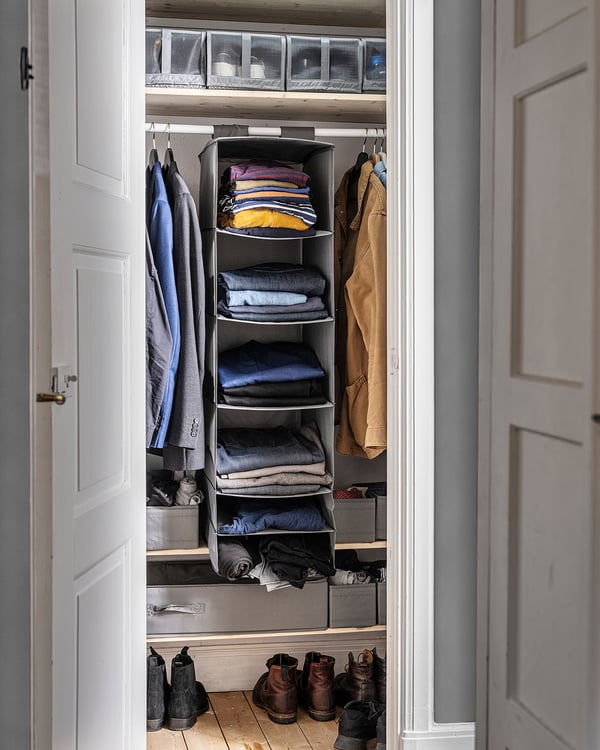 Organised closet with SKUBB folds shelf, grey, fabrics, hanging sections, clean design.