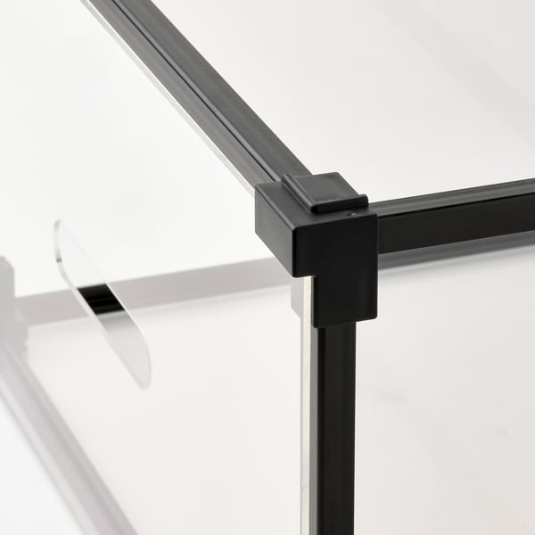 Close-up of modern, black metal corner joint on clear plastic box.