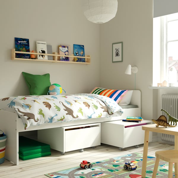 Kids bedroom with SLÄKT bed, dinosaur bedding, toy car, books, and under-bed storage.