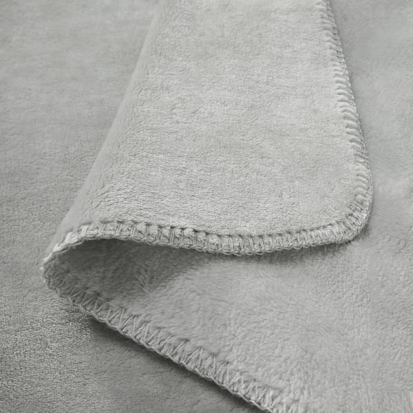 A plush, light grey throw blanket with soft, folded edges and a velvety texture. Recycled polyester material, showcasing luxurious feel and quality.