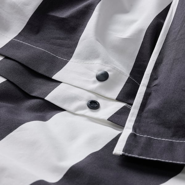 Close-up of striped duvet cover with press-stud closure detail.