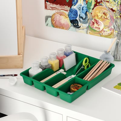 Green SMÄCKER tray organises art supplies, fitting well on a table.