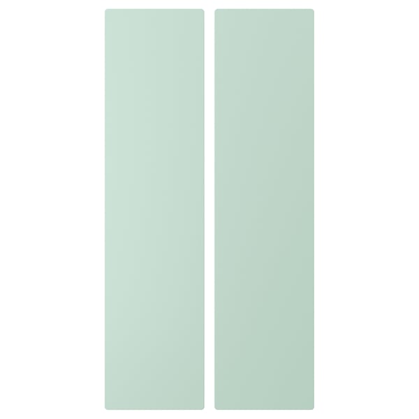 Two tall, light green, rectangular doors in soft pastel tones, made of fiberboard, side by side, designed for SMÅSTAD storage.