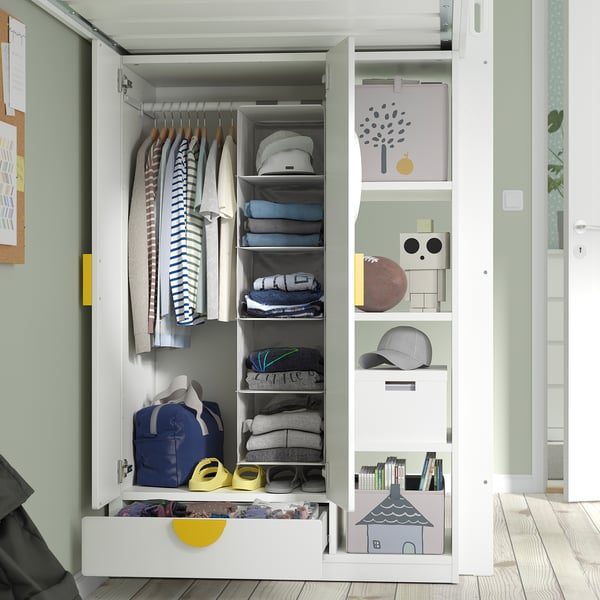 Open wardrobe showing neatly organised childrens clothes, accessories, and storage boxes.