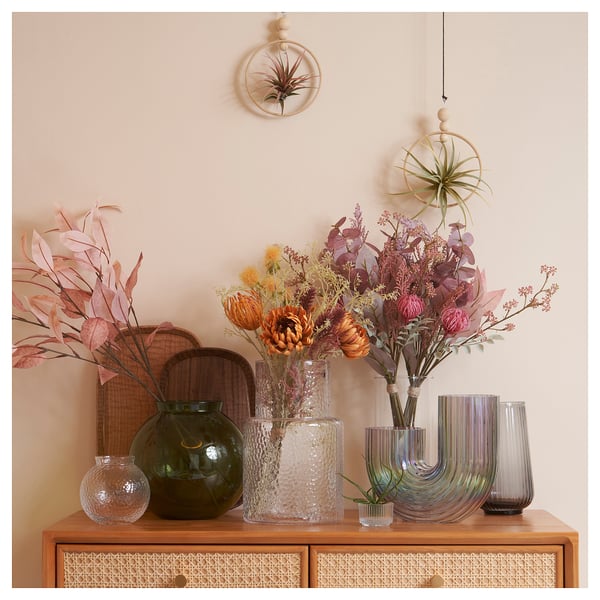 Wooden cabinet with vases of dried flowers & air plants.