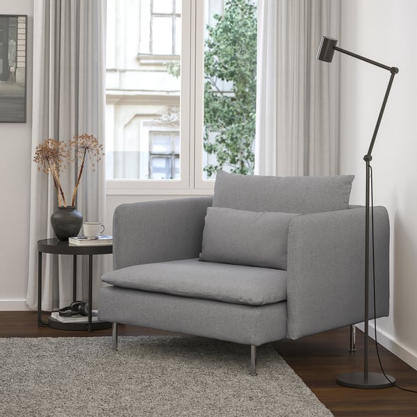 Modern grey SÖDERHAMN chair in cosy room, wooden floor, black floor lamp, side table with vase.