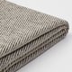 Folded textured striped blanket, beige and grey, smooth knit pattern.