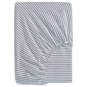 A blue and white striped fitted sheet named SOLFIBBLA made of 100% cotton with recycling content. Rectangular shape with elastic sides.