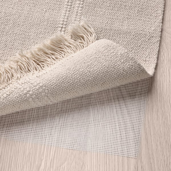 A woven rug with a mesh non-slip backing for secure placement on various flooring types. Machine washable for easy cleaning.