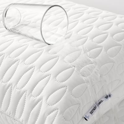 White quilted pillow protector with glass, waterproof inner layer.