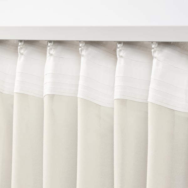 White sheer curtains hang with pleats, showing heading tape and hooks, designed for easy installation and light diffusion.