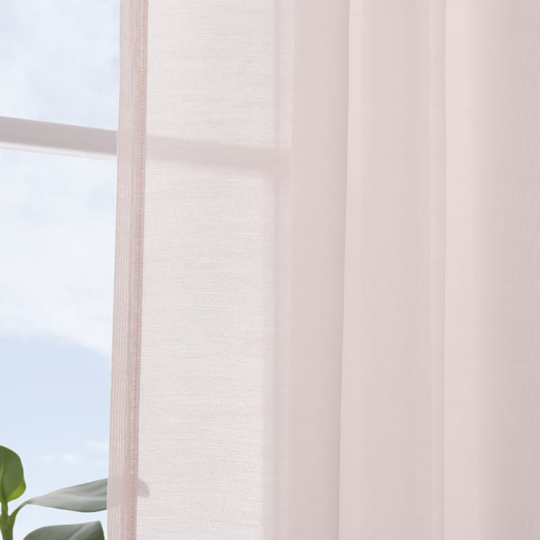 Delicate pink sheer curtains hang near a window, softening sunlight and offering daytime privacy.