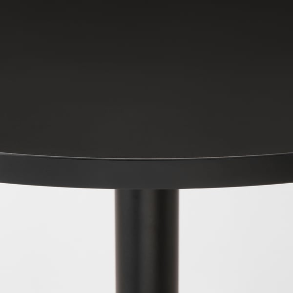 Black circular table with smooth, glossy surface and sturdy central support.