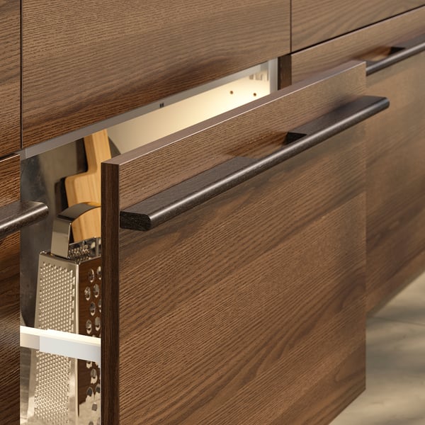 Wooden kitchen cabinets with dark brown handles.