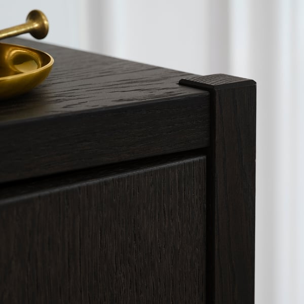 Black STOCKHOLM 2025 cabinet detail: sleek, dark wood finish and durable construction.