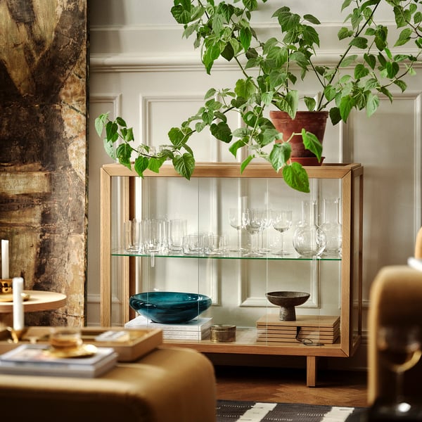 STOCKHOLM 2025 cabinet: oak wood, glass, modern, 60x40x90cm; displays glasses, books, plants; wooden shelves, adjustable feet.