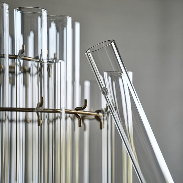 Chandelier with multiple glass cylinders suspended by metal hooks, reflecting high-quality design and craftsmanship.