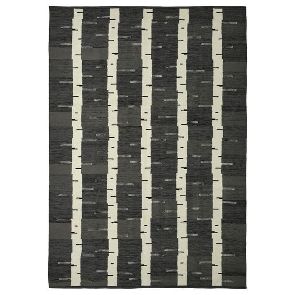 A rectangular grey wool rug with a birch tree pattern, reversible, from the stockholm collection.