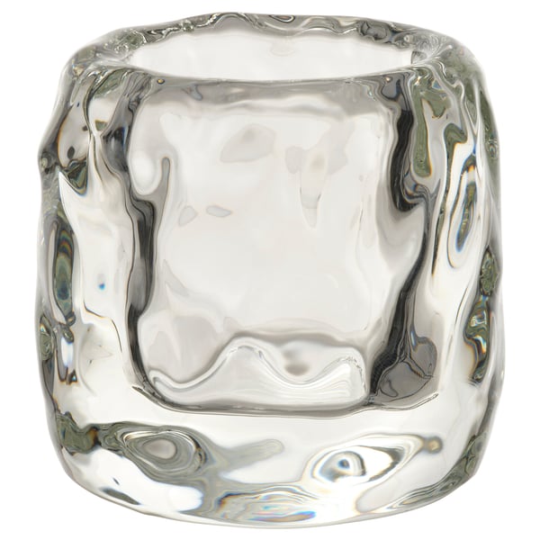 STOCKHOLM 2025 ice cube-shaped tealight holder, clear glass, thick design, elegant, emits warm glow.