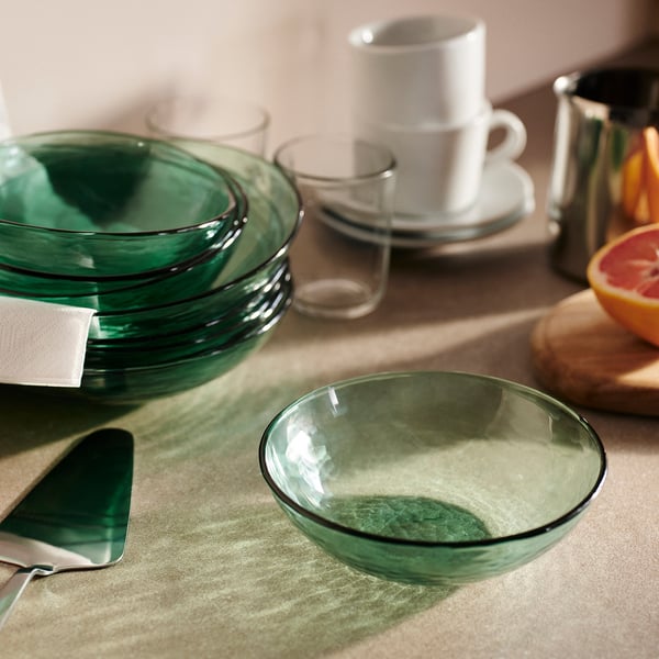 Stacked bowls & cups, tray of citrus, metal utensils, hammered glass.