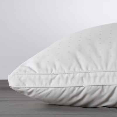 Close-up of a luxurious, supportive pillow with soft, textured cotton cover on a plain bed.