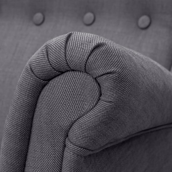 Close-up of high-quality, grey tweed fabric on a upholstered sofa armrest, showcasing its texture and detail.