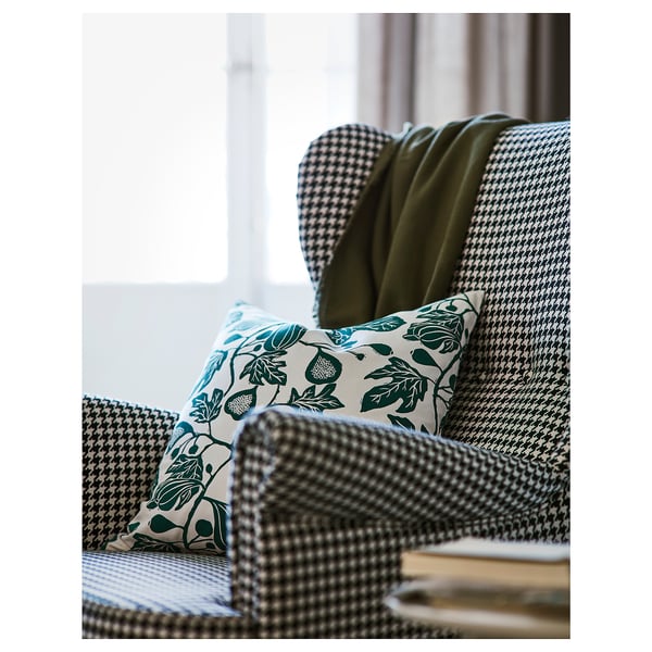 Comfortable houndstooth-patterned armchair with plush pillows, exuding quality and cosiness.
