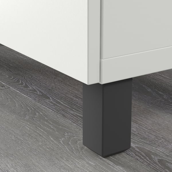 A close-up of STUBBARP legs elevating a white cabinet from a wooden floor, showing their stabilising function.