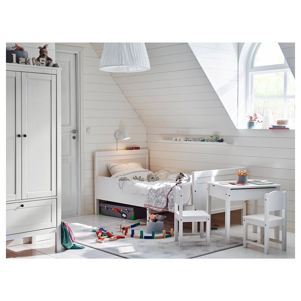 Cosy white kids room with white furniture: bed, desk, chair, and wardrobe. Bright, clean, and inviting.
