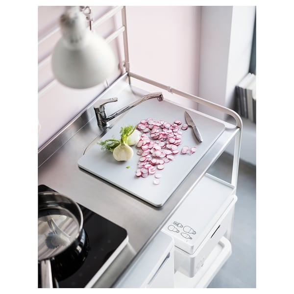 Kitchen sink area with chopped radishes; white modern design, stainless steel