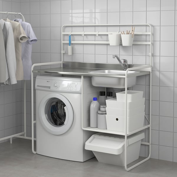 Compact laundry setup. White washing machine, sink, and storage units, efficient for small spaces.