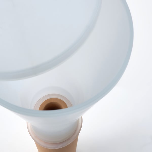 Clear, modern plant self-watering device with white base, terracotta insert, and silicone seal.