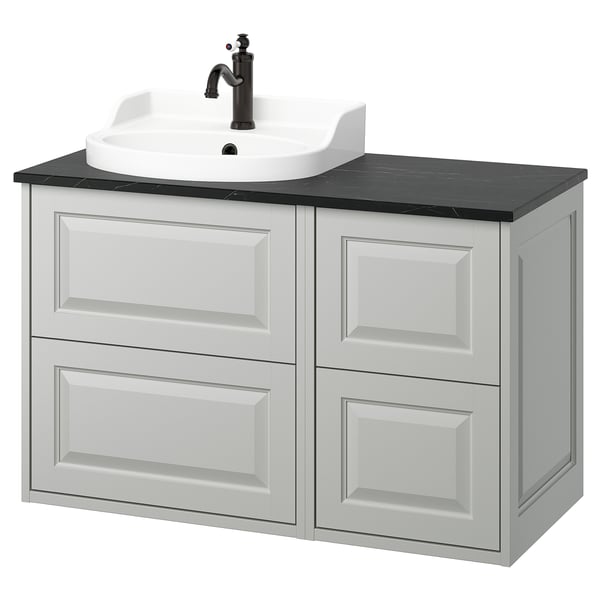A TÄNNFORSEN light grey bathroom vanity with four drawers and a white ceramic sink. It sleek, bevelled panels and a dark countertop.