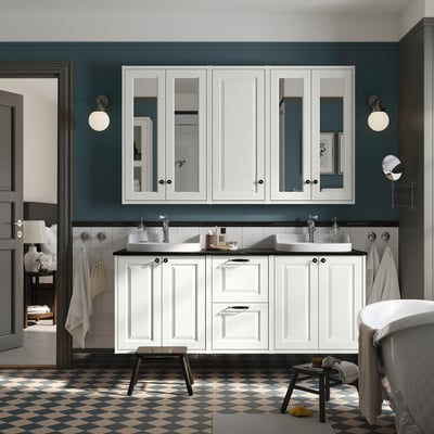 Modern bathroom with TÄNNFORSEN vanity, double sinks, dark teal walls, chequered floor, and wall lights.