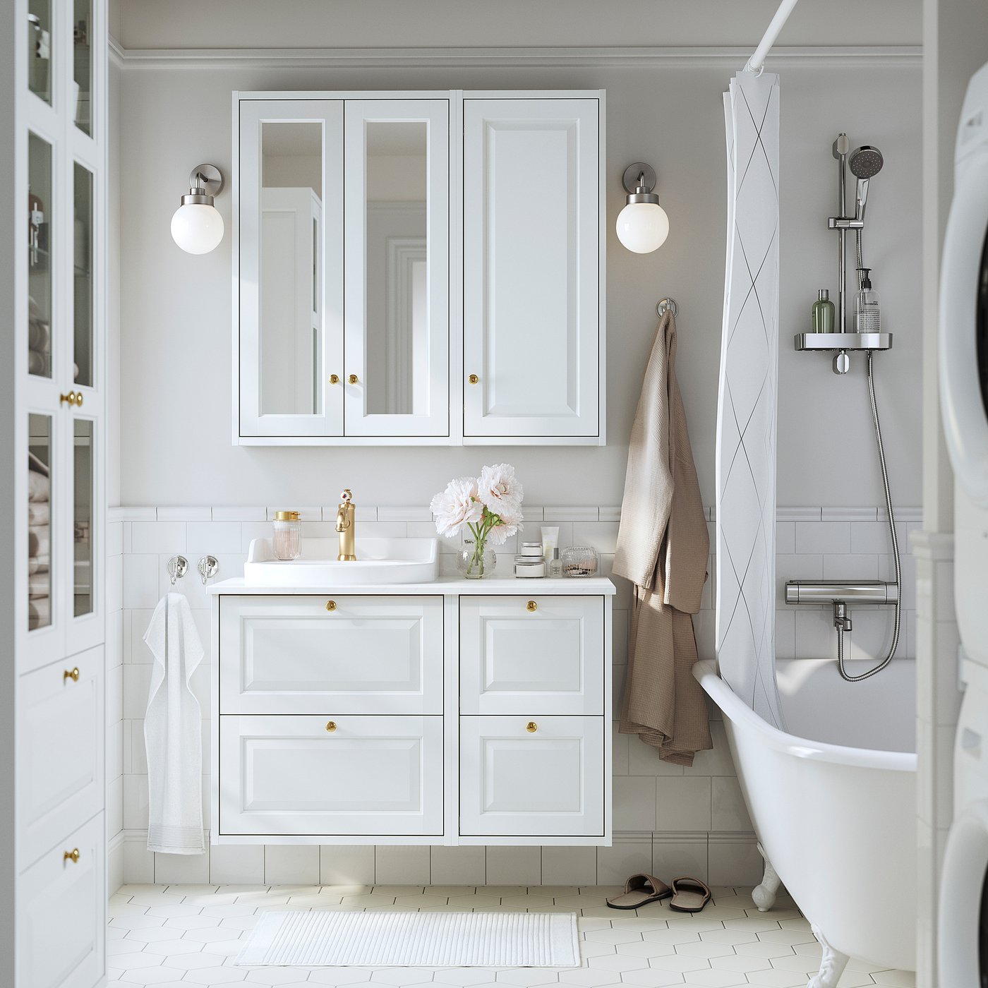 Modern white bathroom with TÄNNFORSEN cabinet, gold accents, glass shelf, and flowers. Shallow cabinet above sink, fitting well between wall lights.