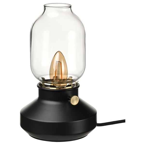 TÄRNABY lamp in black; rounded glass shade tops smooth, dark base; warm, dimmable light.