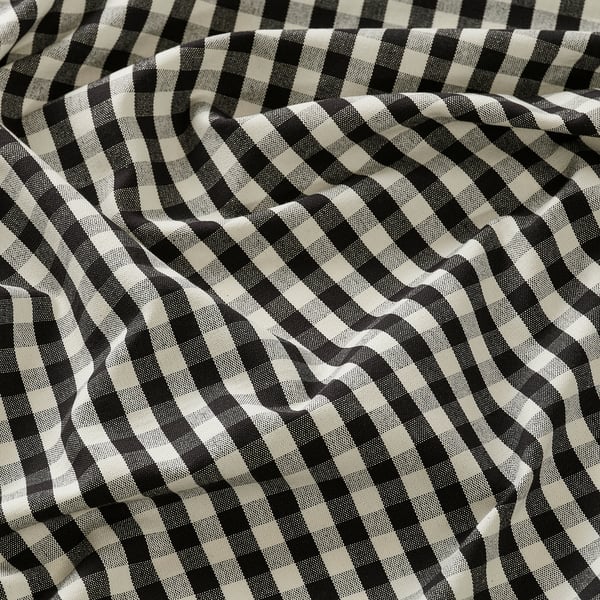 Black and white chequered fabric, tightly woven, laid out in waves.