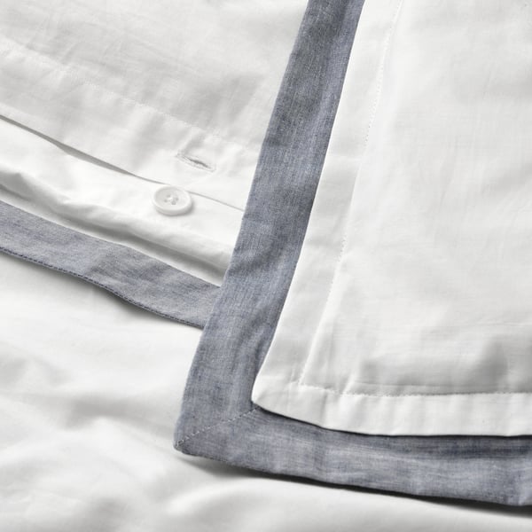 Black-and-white a button on white shirt cuff with grey trim. Shows how button secures shirt sleeve.