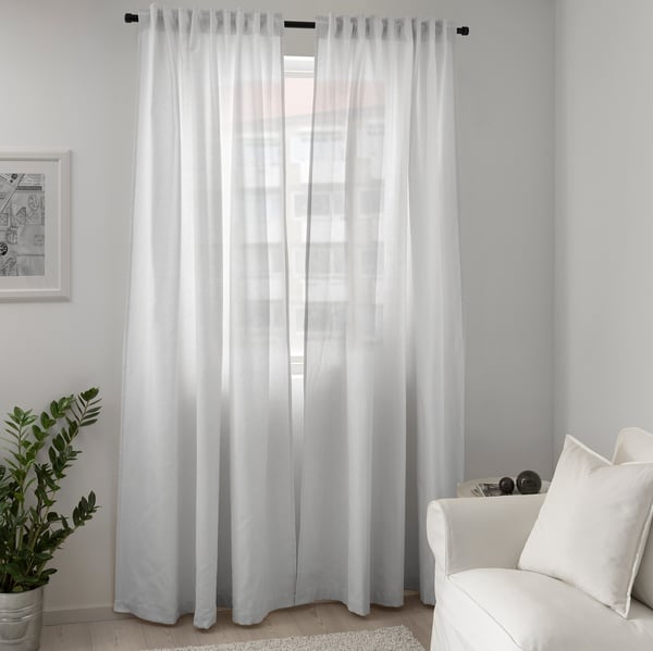 Sheer white curtain frames window, softening light.