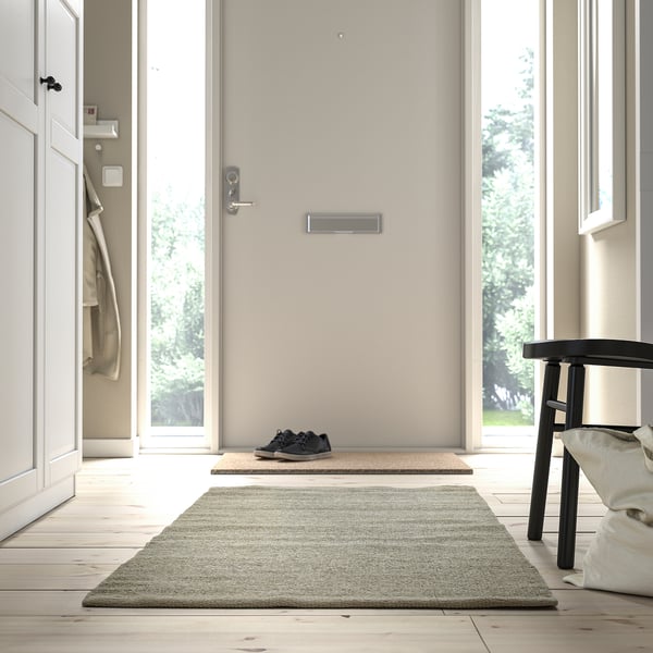 Minimalist entryway with TIDTABELL rug, adding texture and functionality.